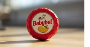 Babybelletje mini cheese snack wrapped in red wax showing creamy texture inside
